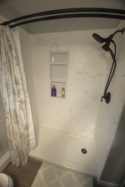 IMG_7395 “Completed Samuel Mueller solid surface shower conversion with marble-look finish, niche, and matte black fixtures in Lancaster PA bathroom”